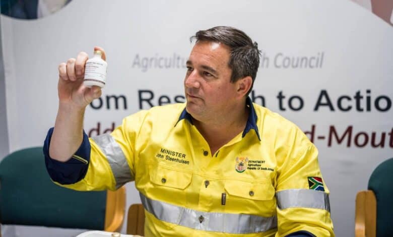 ohn Steenhuisen holding a bottle containing the high-potency vaccine doses