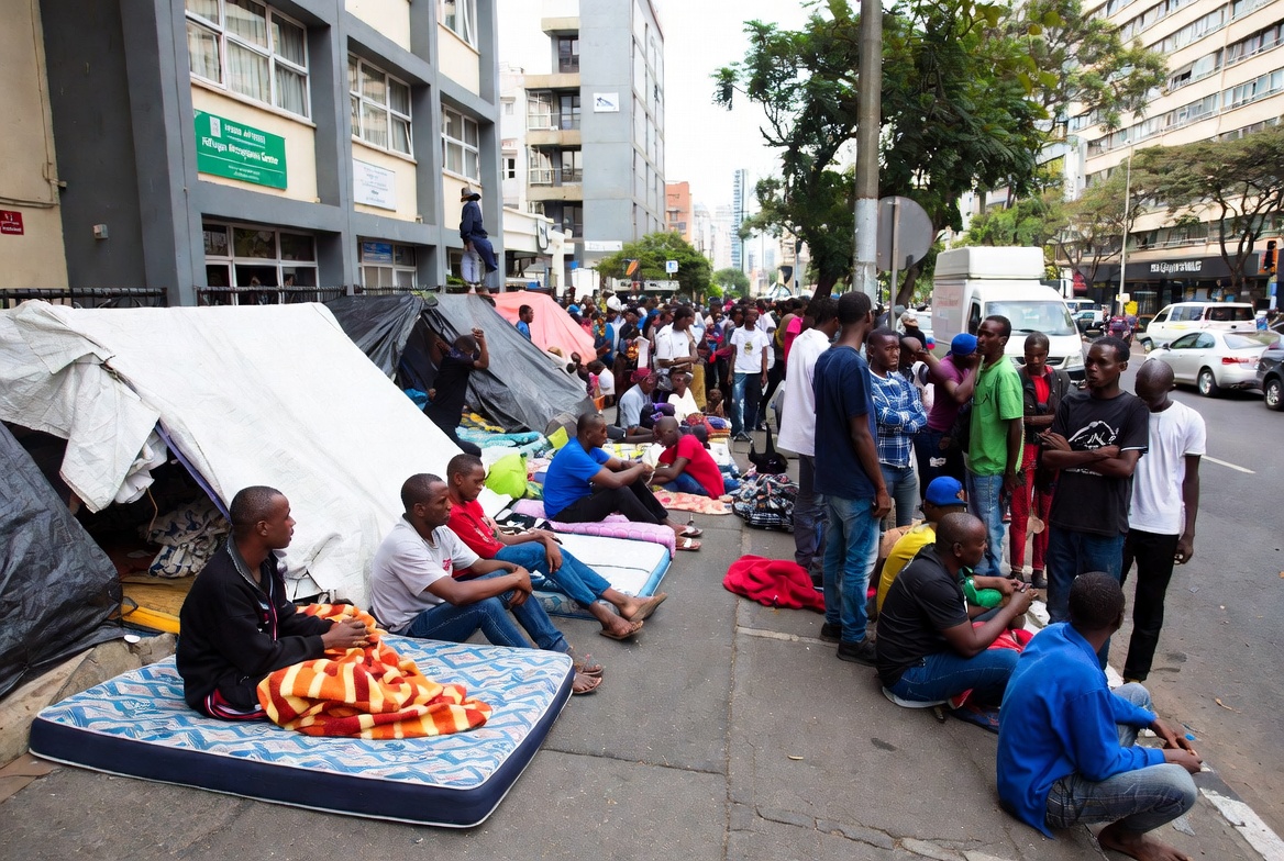 Hundreds of refugees and asylum seekers have been camped outside the Department of Home Affairs Refugee Reception Centre on Che Guevara Road in Berea, Durban, for over a month (as of early July 2026)